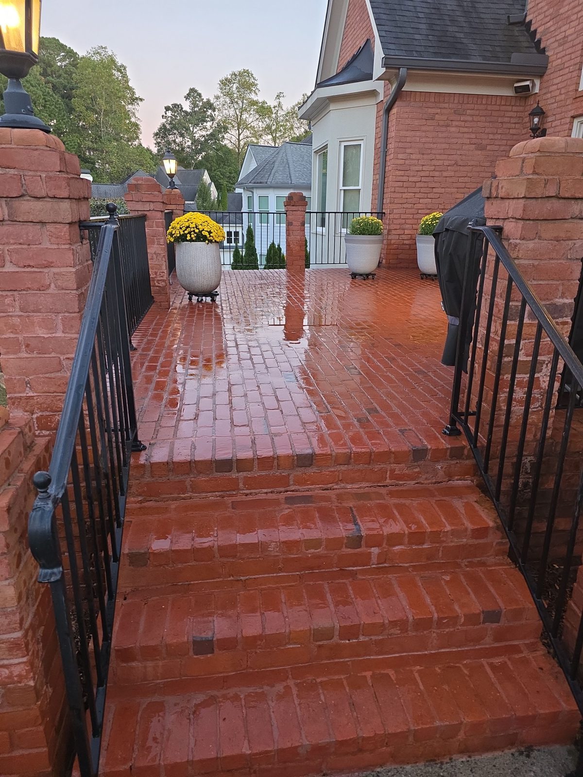 Round surface cleaner on a cleaned aggregate walkway in Thornberry, with the hose running back across the light stone and shrubs on both sides
