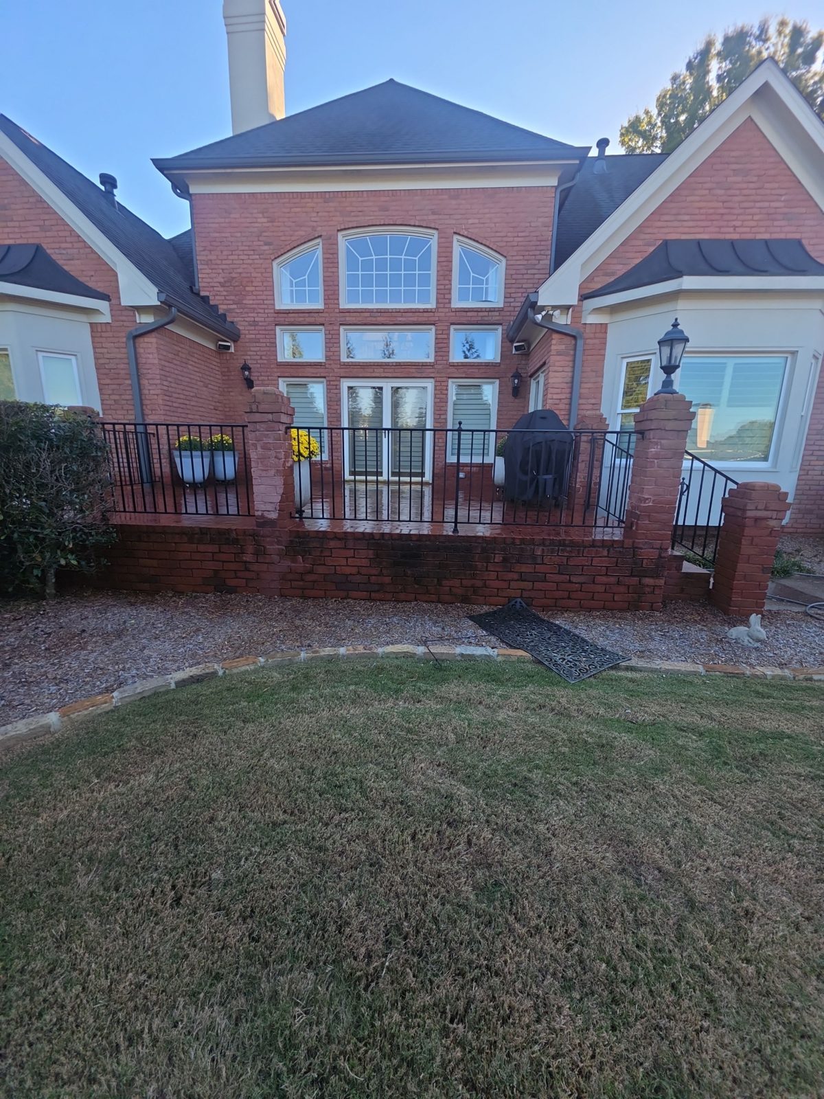 Aggregate walkway and brick step in Thornberry before cleaning, dark with stains and moss, with leaves on the ground