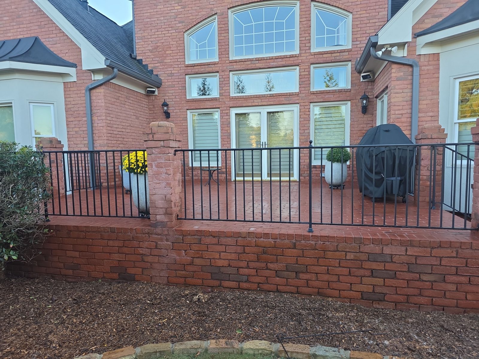 Brick side walkway in Thornberry before cleaning, green with moss, running beside shrubs toward a fence