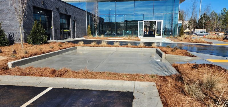 Freshly washed concrete pad and walkway outside a commercial building