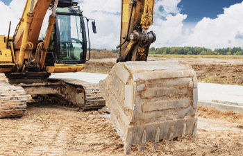 a heavy crawler excavator with a large bucket is getting ready for work